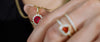Macro close-up of Loretana AAA ruby zirconia pendant and matching heart ring on hand, gold chain detail. Hallmarked 925 sterling silver, Kaunas.