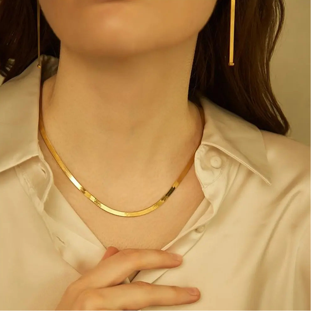 14K aukso plokščias gyvatės grandinėlės vėrinys, derinamas su kitomis subtiliomis auksinėmis grandinėlėmis, kad būtų parodytas jo universalumas kruopščiai sudėto sluoksnių rinkinio stiliuje