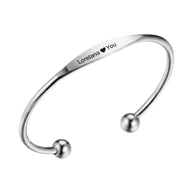 Close up of personalized silver cuff bracelet showing custom letter engraving