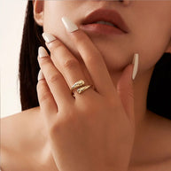 Hand model wearing the 14K gold-plated hammered double teardrop adjustable ring, open back visible behind the finger and the two teardrop heads sitting flush on top. Hallmarked Loretana piece, hand-finished in Kaunas.