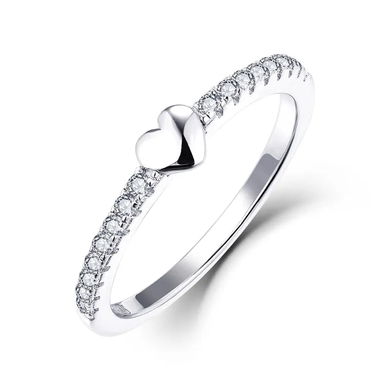 Hand model wearing the silver heart ring, showcasing the polished band and centered heart stone. Hallmarked Loretana piece, hand-finished in Kaunas.
