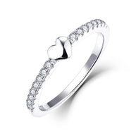 Hand model wearing the silver heart ring, showcasing the polished band and centered heart stone. Hallmarked Loretana piece, hand-finished in Kaunas.